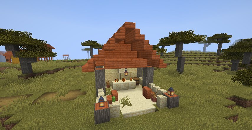 A sandstone shrine with an acacia roof, an altar with candles and a small courtyard with benches and lanterns, in a savanna